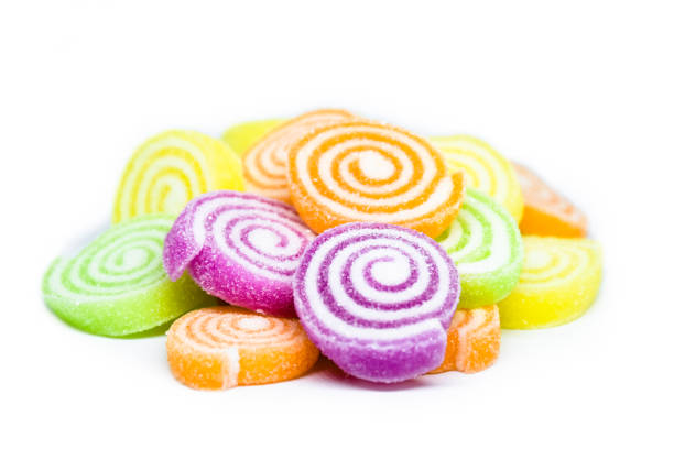 Isolated multicolored jelly candy mix white granulated sugar on white background, soft and selective focus.