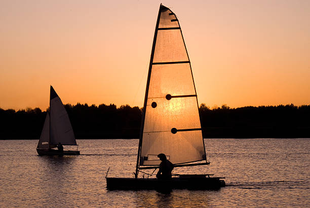 sonnenuntergang hinter ein segel-boot - sailboat sunset nautical vessel sun stock-fotos und bilder
