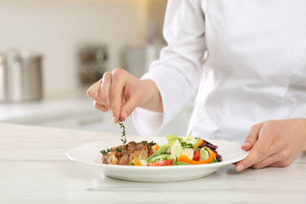 istock Professional chef decorating delicious dish with thyme at marble table, closeup. Space for text 1780876782