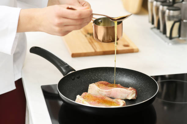 istock Professional chef pouring sauce into frying pan in kitchen, closeup 1780877297