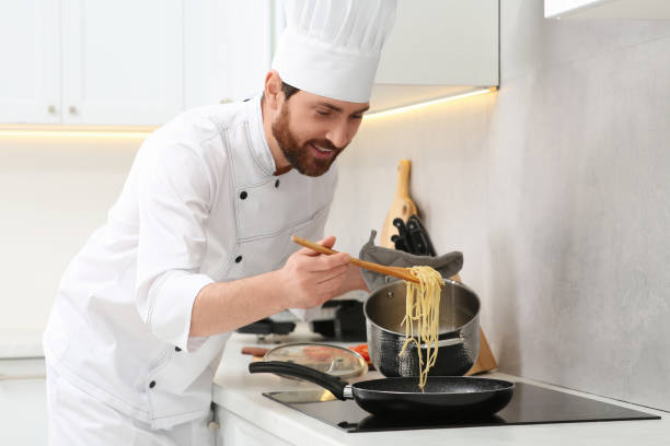 istock Chef putting delicious spaghetti from pot into frying pan indoors 1780878891