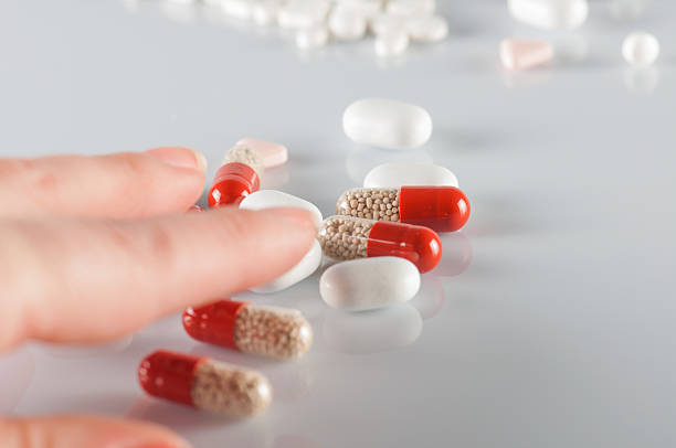 tomar comprimido - vitamin pill picking up pill capsule imagens e fotografias de stock