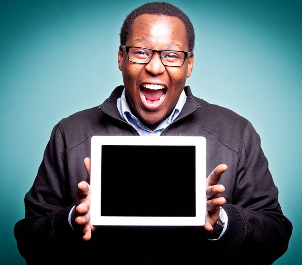 istock Young Male Holding Tablet Device isolated on blue background 178088917