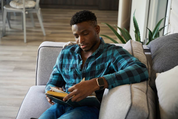 istock Curly-haired man in comfortable clothes sits on the sofa 1780901491