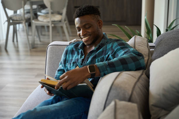 istock Happy African American guy sitting on the sofa 1780901492