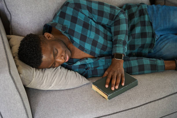 istock African American guy dozed off with a book on sofa 1780901501