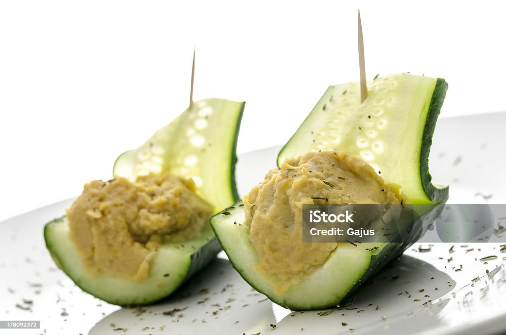 Cucumber boats filled with hummus Cucumber boats filled with hummus on a decorated plate. Cucumber Stock Photo