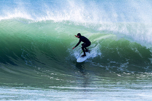 A man surfing through a water barrel