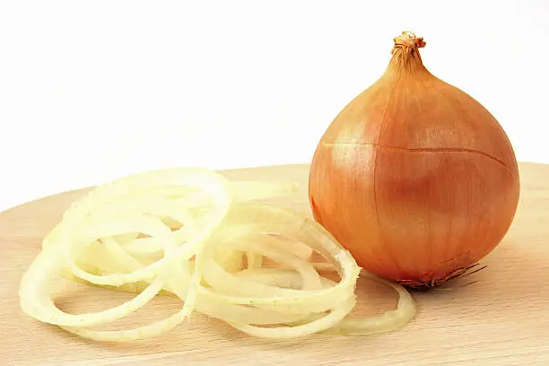 Big onion on a wooden board with onion rings
