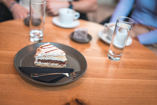 Close up on a slice of cake on served on a plate in a coffee house.
