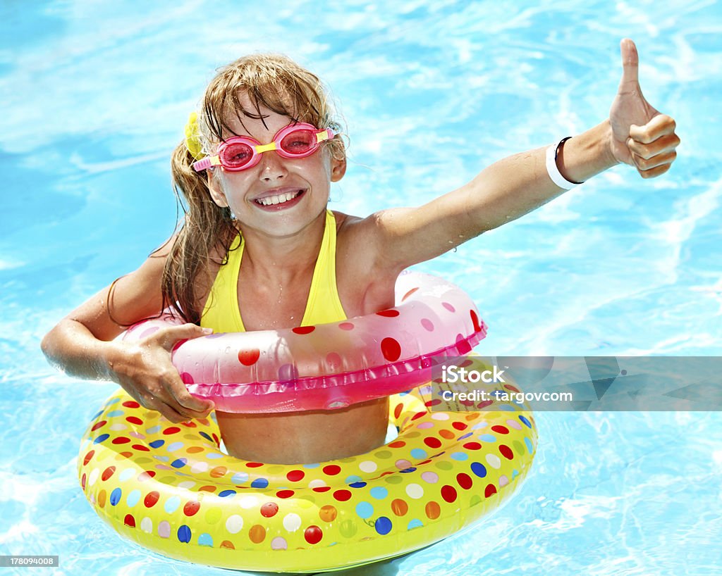 Kid sitting on inflatable ring. Child sitting on inflatable ring in swimming pool. Activity Stock Photo