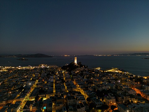 Aerial view over North Beach of Coit Tower as the sun comes up behind the famous landmark.