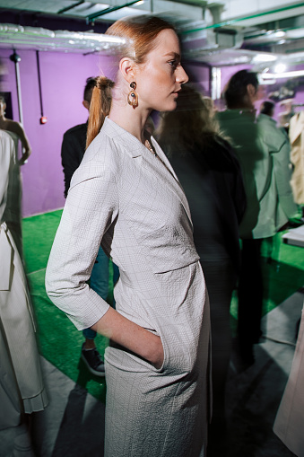 Female portrait of fashion woman at the backstage of fashion week show. Lifestyle photography, behind the scenes of new clothing collection. Girl wear by fashion designer. Haute Couture photo.