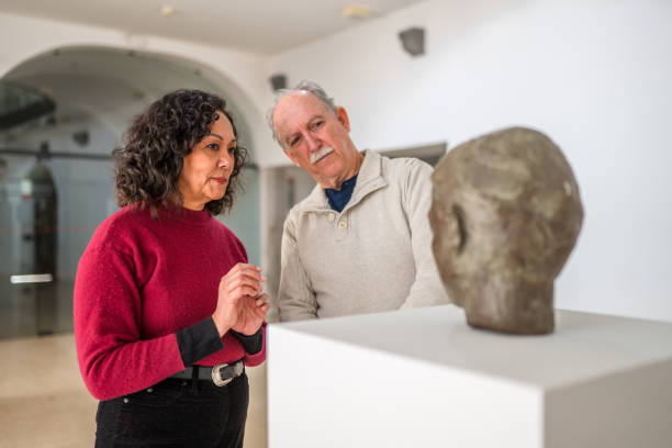 romantic mixed couple at an art biennale - pedestal collection showing old imagens e fotografias de stock