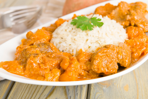 Lamb and sweet potato peanut stew served with white rice. Caribbean and West African traditional dish.