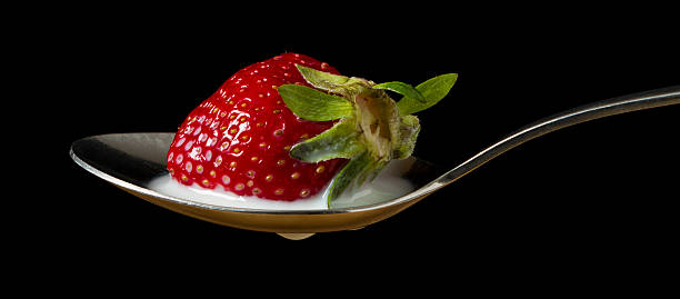 istock red, ripe strawberry falling in spoon with milk 178095419