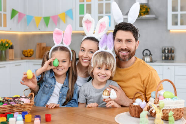 istock Happy family with Easter eggs at table in kitchen 1780964638
