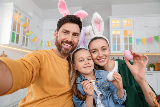 istock Happy family making selfie while painting Easter eggs in kitchen 1780964639