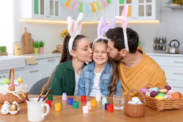 istock Happy family with Easter eggs at table in kitchen 1780964664
