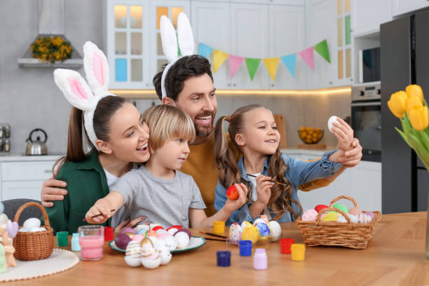 istock Happy family painting Easter eggs at table in kitchen 1780965097