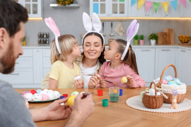 istock Happy family painting Easter eggs at table in kitchen 1780965243