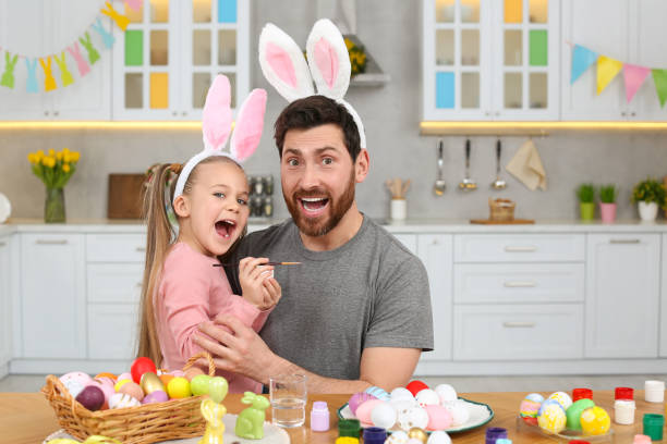 istock Emotional father with his cute daughter and Easter eggs at table in kitchen 1780967587