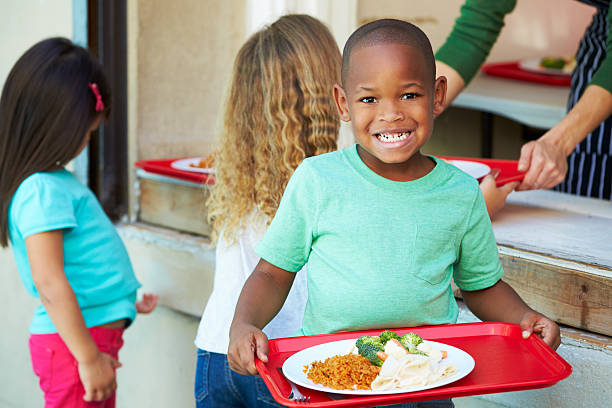 élèves de primaire collecte déjeuner diététique servi à la cafétéria - cantine photos et images de collection