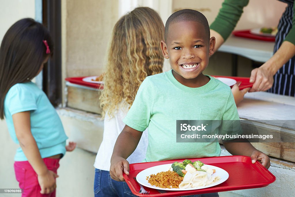 Elementari alunni raccolta sano pranzo In mensa - Foto stock royalty-free di Bambino