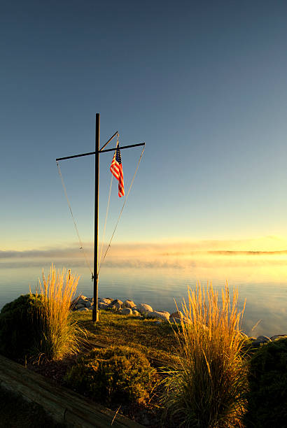 drapeau américain sur la perche au lever du soleil au bord du lac, dans le minnesota - leech photos et images de collection