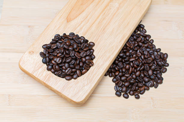 Raw coffee beans on wooden table top, close-up shot above. before drinking
