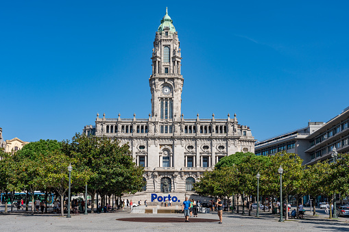 People are visiting the town square. Porto City Hall (Pacos do Concelho) and City Sign - Porto, Portugal.