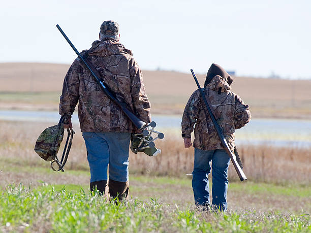 grandpa et petit-fils vont de chasse au canard - chasser photos et images de collection