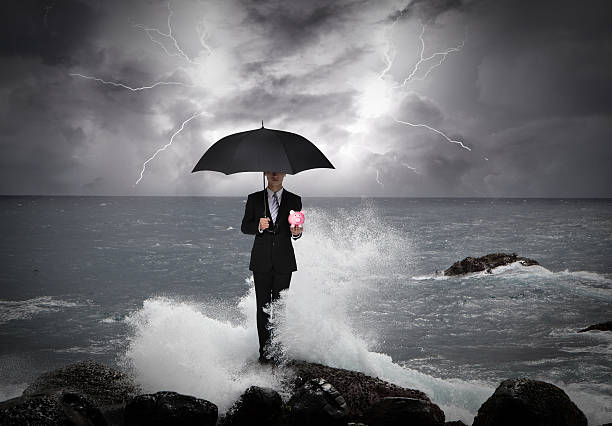 бизнес человек под зонтик на море - security umbrella rain currency стоковые фото и изображения