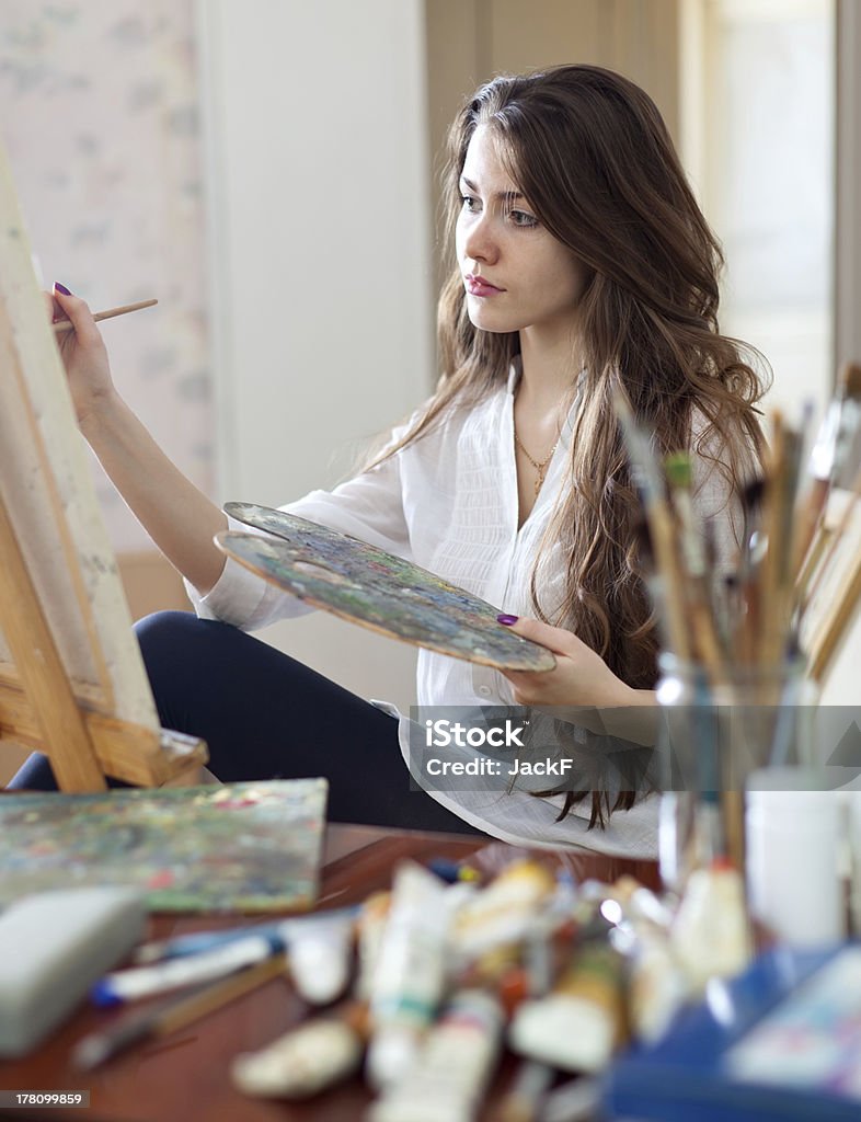 artist painting picture on canvas with oil paints artist painting picture on canvas with oil paints in her workshop 20-29 Years Stock Photo