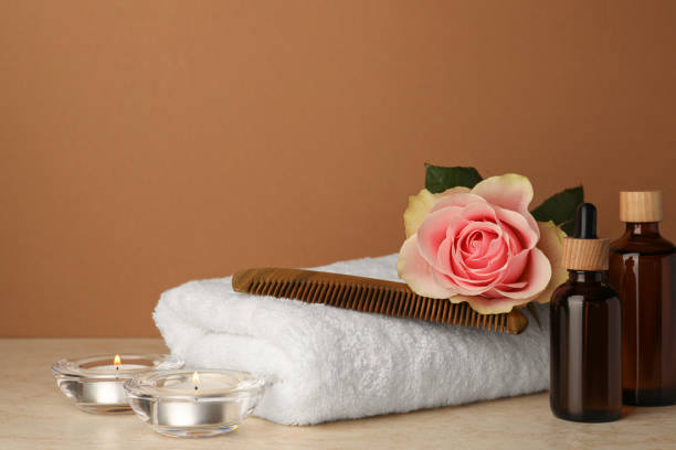 istock Composition with different spa products, beautiful flower and burning candles on beige table against brown background. Space for text 1781004938