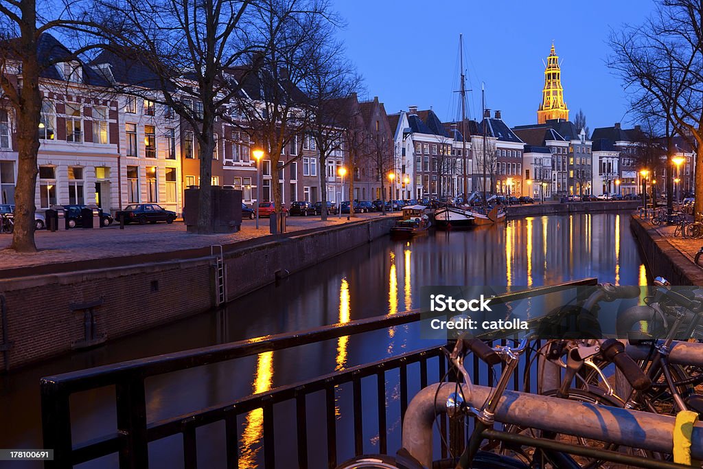 street along canal at night in Groningen Dutch street with bicycles bu canal in dusk, Groningen Architecture Stock Photo