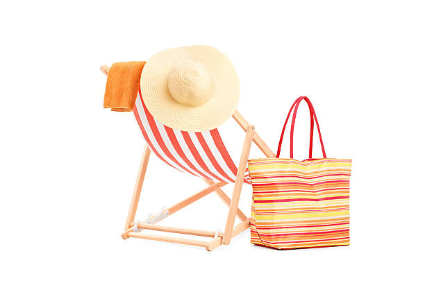 Sun lounger with orange stripes and summer accessories, isolated on white background