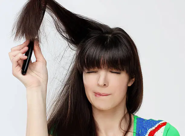 Photo of Woman  trying to get a brush out of her hair