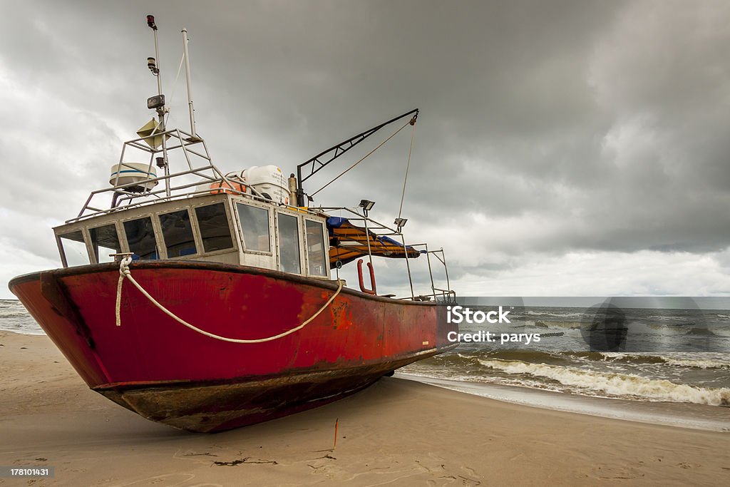 Fishing boast on the beach. Old fishing boat on the beach in Rewal - Poland. Bay of Water Stock Photo