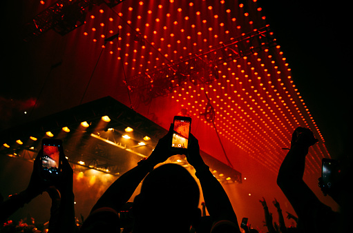 Silhouetted fans with phones in the air