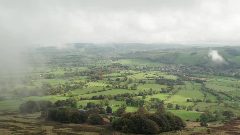 Cinematic reveal of cloudy valley in Peak District National Park. Aerial clip of British countryside fields in 4K