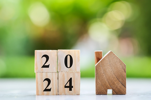 Happy new year 2024. House model with 2024 wooden blocks number. New year, New home, Real estate, Property investment and asset management, Business and financial concept.