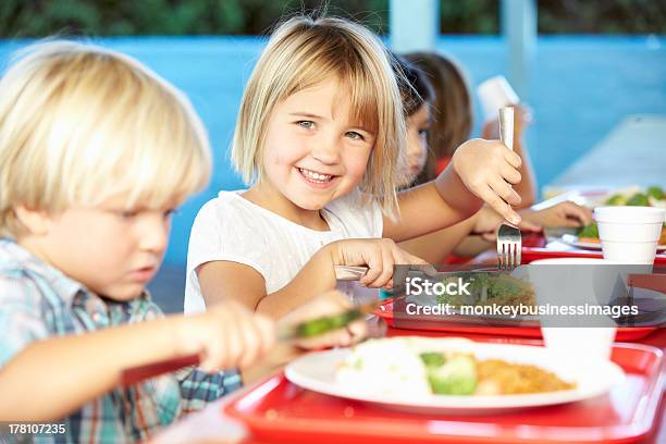 Alunni Elementari Godendo Sano Pranzo In Mensa - Fotografie stock e altre immagini di Bambino - Bambino, Edificio scolastico, Mensa