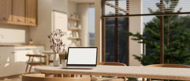 istock A laptop mockup on a dining table in a beautiful Scandinavian kitchen in a modern spacious home. 1781093522
