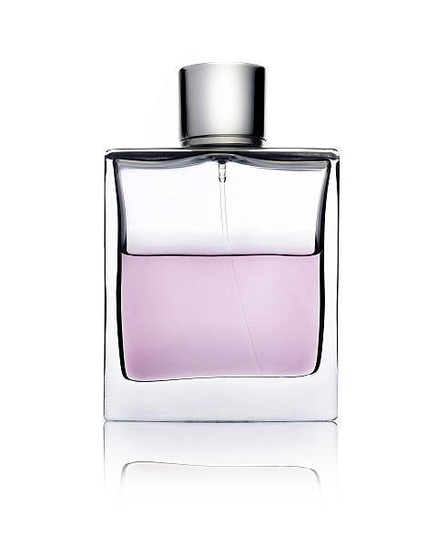 Clear glass bottle with pink perfume on white surface