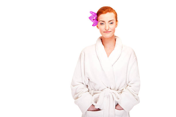 Woman in bathrobe smiling with flower stock photo