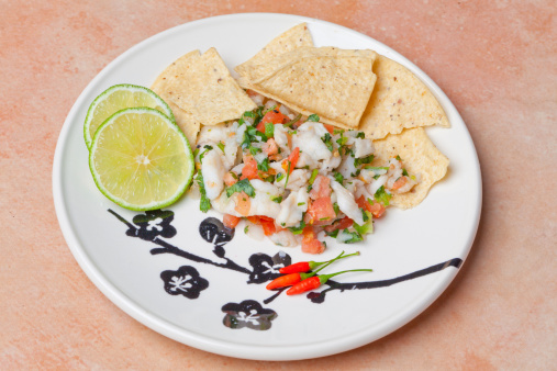Ceviche Platter, ceviche with corn chips and lime on a plate with chili peppers