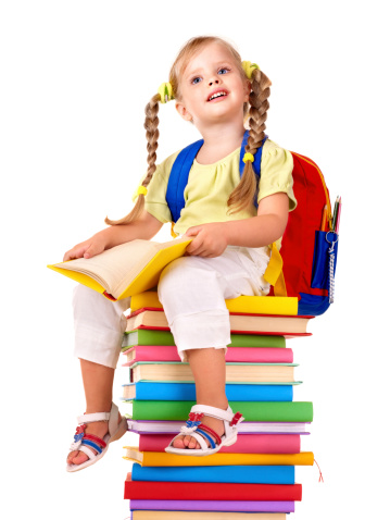 Little girl sitting on pile of books. Isolated.