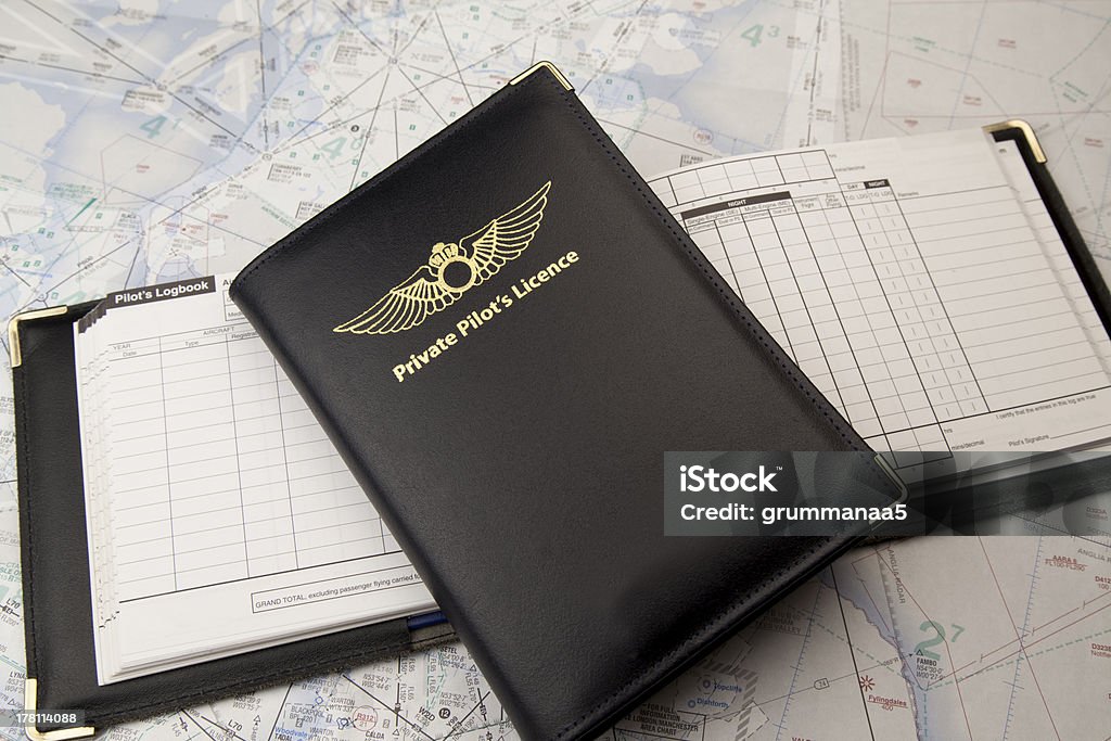 Private pilots license on logbook and chart Private pilots license on an open logbook placed on a navigational chart. Diary Stock Photo