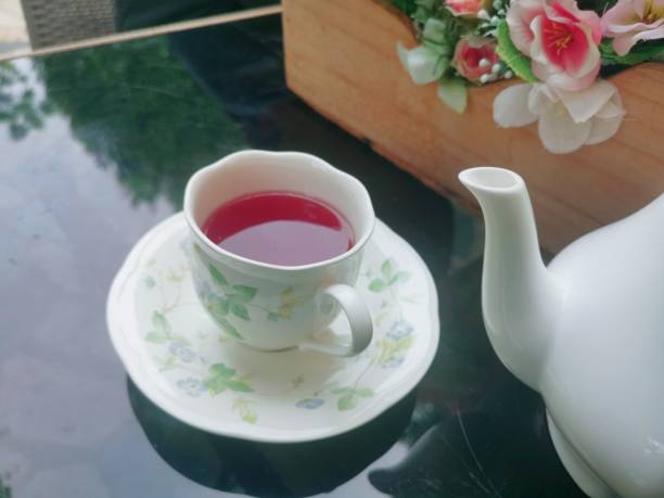 istock Pink rose tea flowers and cup on table 1781155910